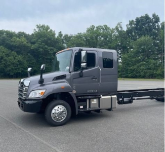Hino L6 cab chassis truck in a parking lot showing the tractor cabin and side fuel tanks with wheels and chassis extending rearward
