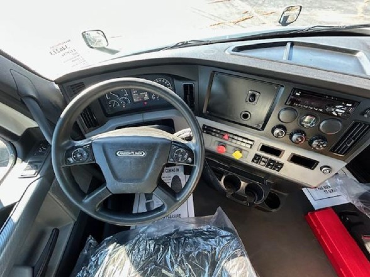 Dashboard and steering wheel of a Freightliner Cascadia 126 truck interior.