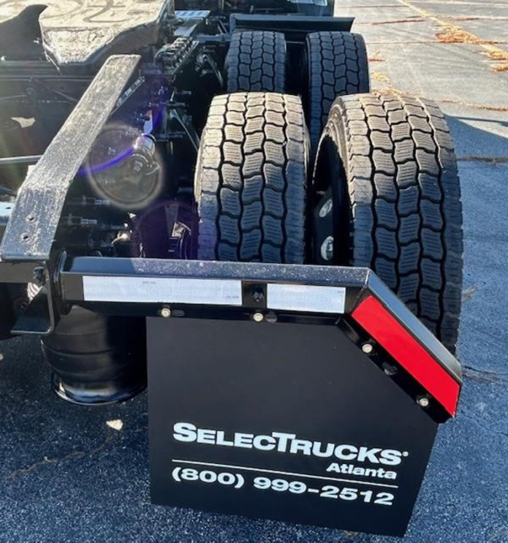 Freightliner Cascadia 126 tractor cab rear view showing dual rear tires and a SelectTrucks Atlanta mudflap with phone number.