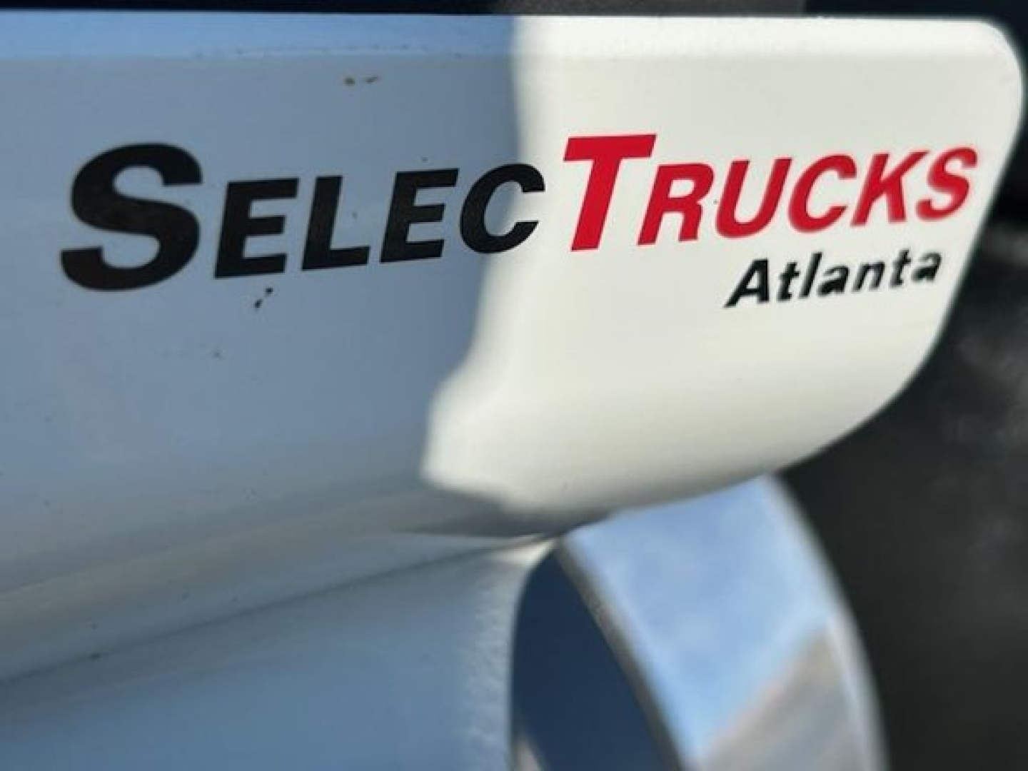 Truck side panel with 'SelecTrucks Atlanta' branding and partial reflection.