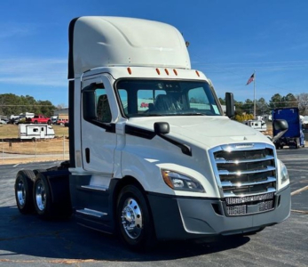 White Freightliner Cascadia 126 day cab truck front left view showing chrome grille, Headlights, side mirror, and stacked cab height, no visible text.