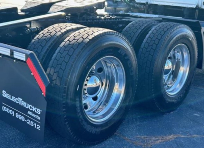 Freightliner Cascadia 126 rear wheels and fender showing dual rear axles with polished aluminum rims and tire treads.
