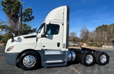 Truck cab in side profile showing Freightliner Cascadia 126, white exterior, with multiple axles and chrome wheels.