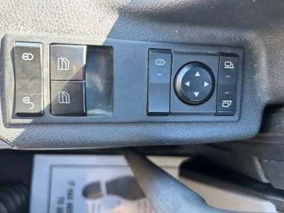 Operator controls on truck door panel with window/lock switches and a circular joystick-like control.
