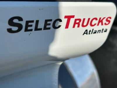 Truck side panel with 'SelecTrucks Atlanta' branding and partial reflection.