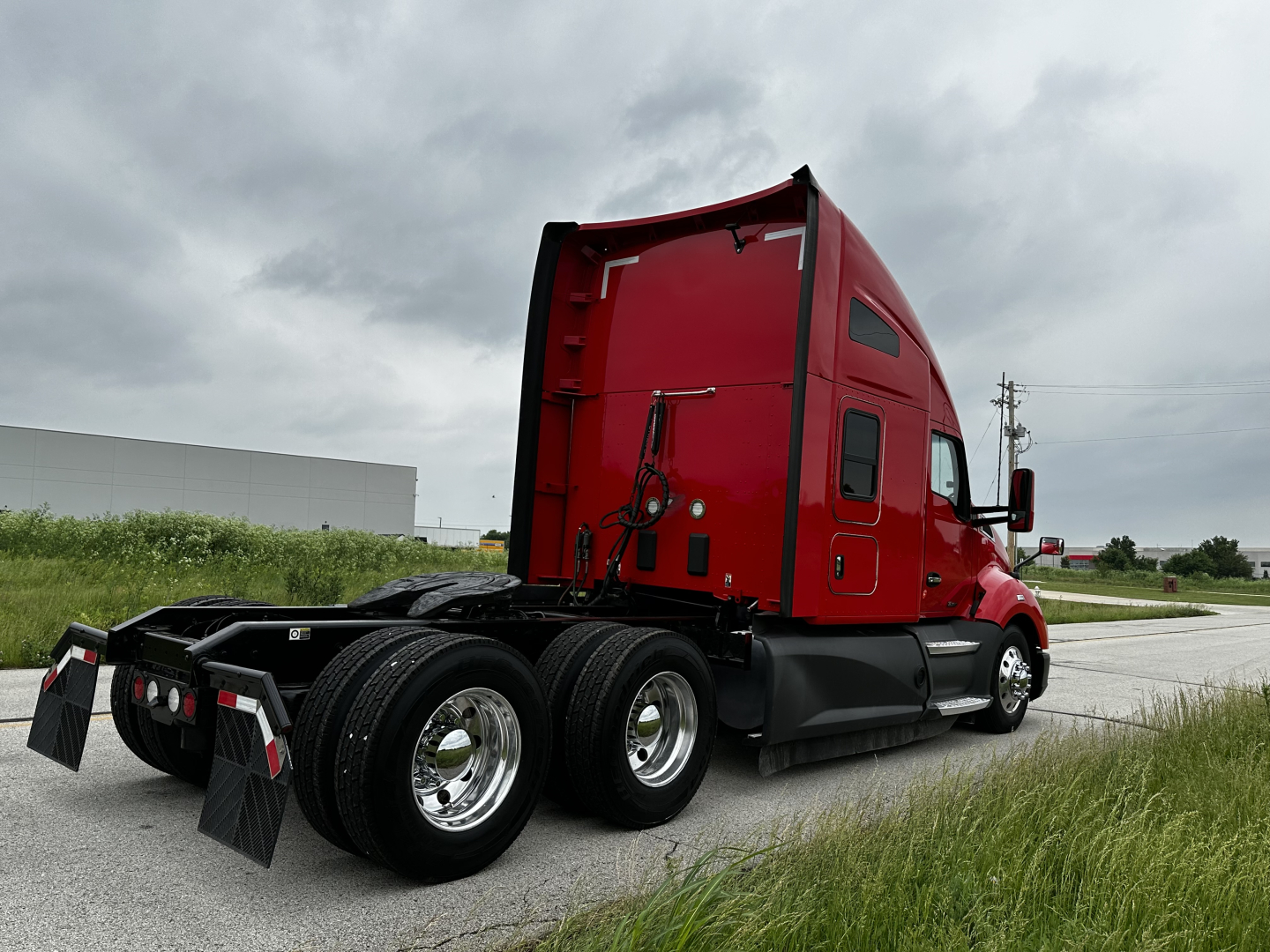 Kenworth T680 tractor-trailer cab in red with sleeper, rear wheels and chassis visible.