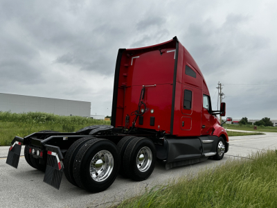 Kenworth T680 tractor-trailer cab in red with sleeper, rear wheels and chassis visible.