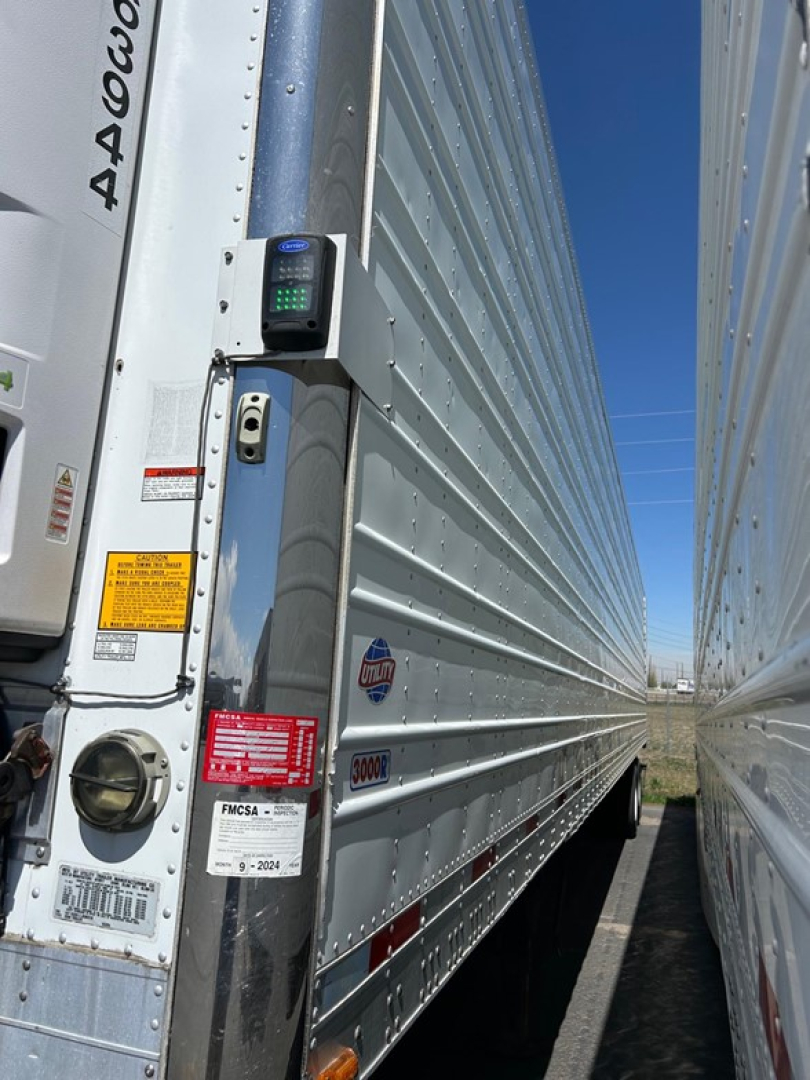 Trailer door area of a 2018 Utility 3000R reefer trailer showing a rider scale/QR reader and door edge; visible labels and stickers including stock number UE11483.
