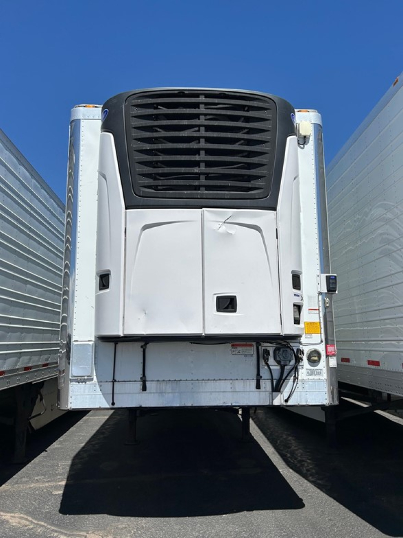 Utility reefer trailer rear view showing refrigeration unit and doors with mounting hardware.