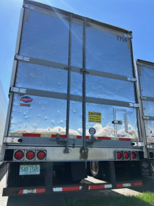 Trailer rear of 2018 Utility 3000R reefer with metal doors, CAUTION sticker, and taillights.