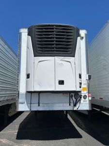 Utility reefer trailer rear view showing refrigeration unit and doors with mounting hardware.