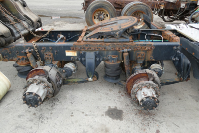 Freightliner Cascadia 125 chassis showing rear axle hubs and drive components with rust and wear.