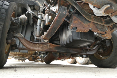 Underneath view of Freightliner Cascadia 125 front undercarriage showing suspension, drivetrain, and frame components.
