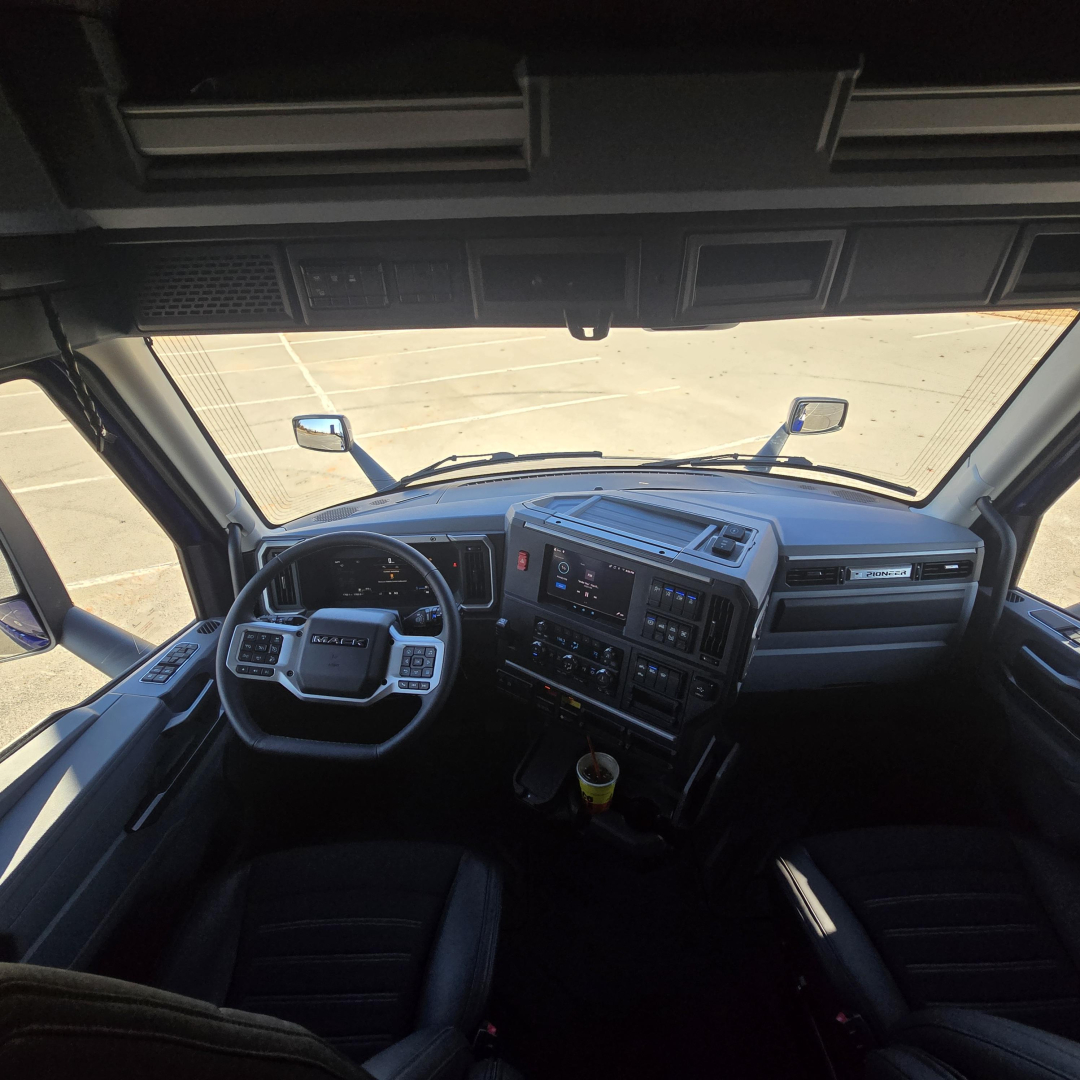 Cab interior of a 2026 Mack PR64T76H truck showing dashboard, steering wheel, and front seats.