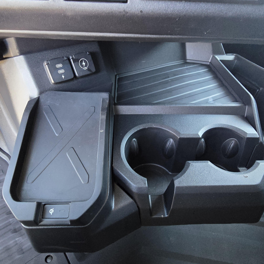 Cup holders and storage area in Mack PR64T76H dashboard with USB/12V ports and cup slots visible.
