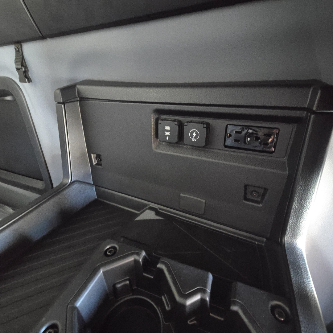 Dashboard area of a 2026 Mack PR64T76H sleeper cab showing power/USB outlets and a blank panel.