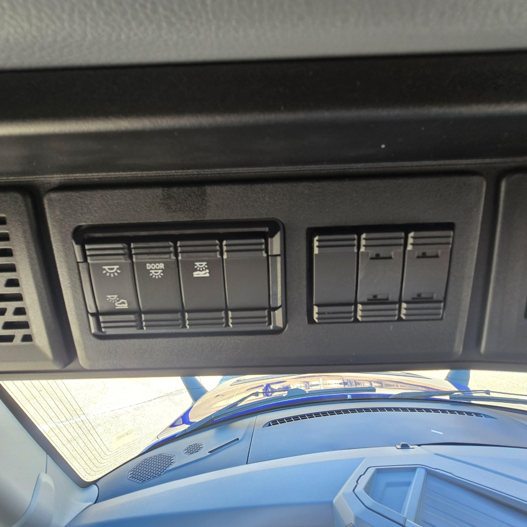 Dashboard panel with switches in Mack PR64T76H truck showing light controls and blank switch panels.
