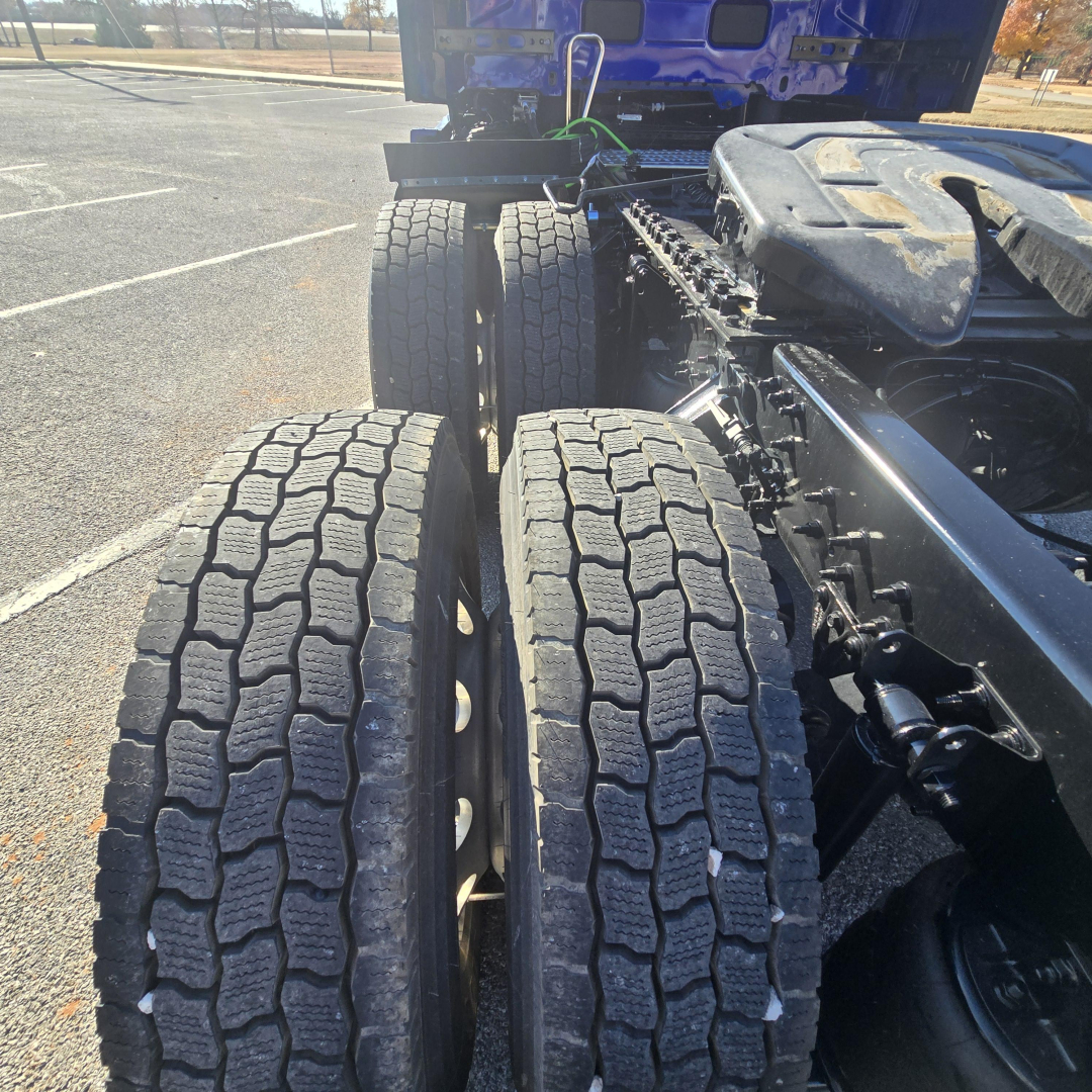 Rear view of a 2026 Mack PR64T76H truck drivetrain showing tandem rear axles and dual tires with tread pattern.