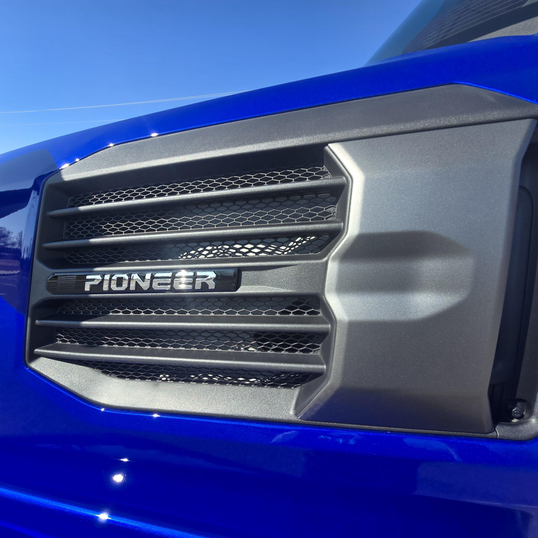Pioneer truck grille with blue hood showing front view of Mack PR64T76H cab; emissions badge not visible.