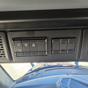 Dashboard panel with switches in Mack PR64T76H truck showing light controls and blank switch panels.