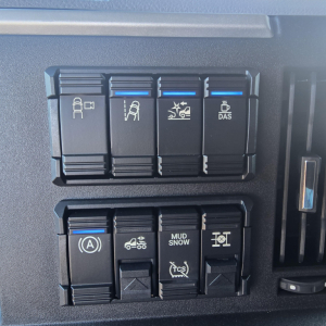 Dashboard switches panel in new Mack PR64T76H showing multiple labeled controls and blue indicator lines.