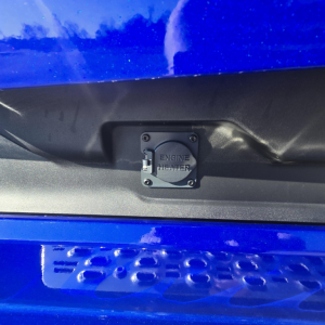Inline view of engine heater cover on Mack PR64T76H, plastic engine access panel with screws.