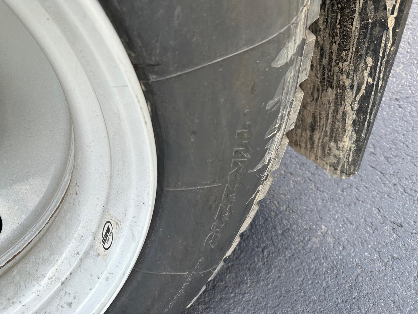 Truck trailer wheel and tire with mudguard showing tire sidewall and Rim