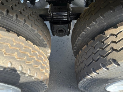 Trailer undercarriage with dual rear axles and large off-road tires, showing chassis and suspension components for a 2025 Ranco Quarter Frame End Dump.