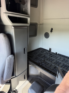 Volvo VNL64T760 cab interior showing sleeper area with step and storage panel, side wall vent, and entry area.