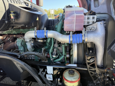 Volvo VNL64T760 engine bay showing large intake piping, coolant reservoir, and turbo machinery in a sleeper truck.