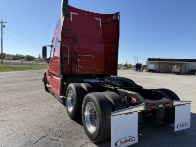 Volvo VNL64T760 truck tractor rear view showing dataset of dual rear axles and mud flaps with MHC logo.