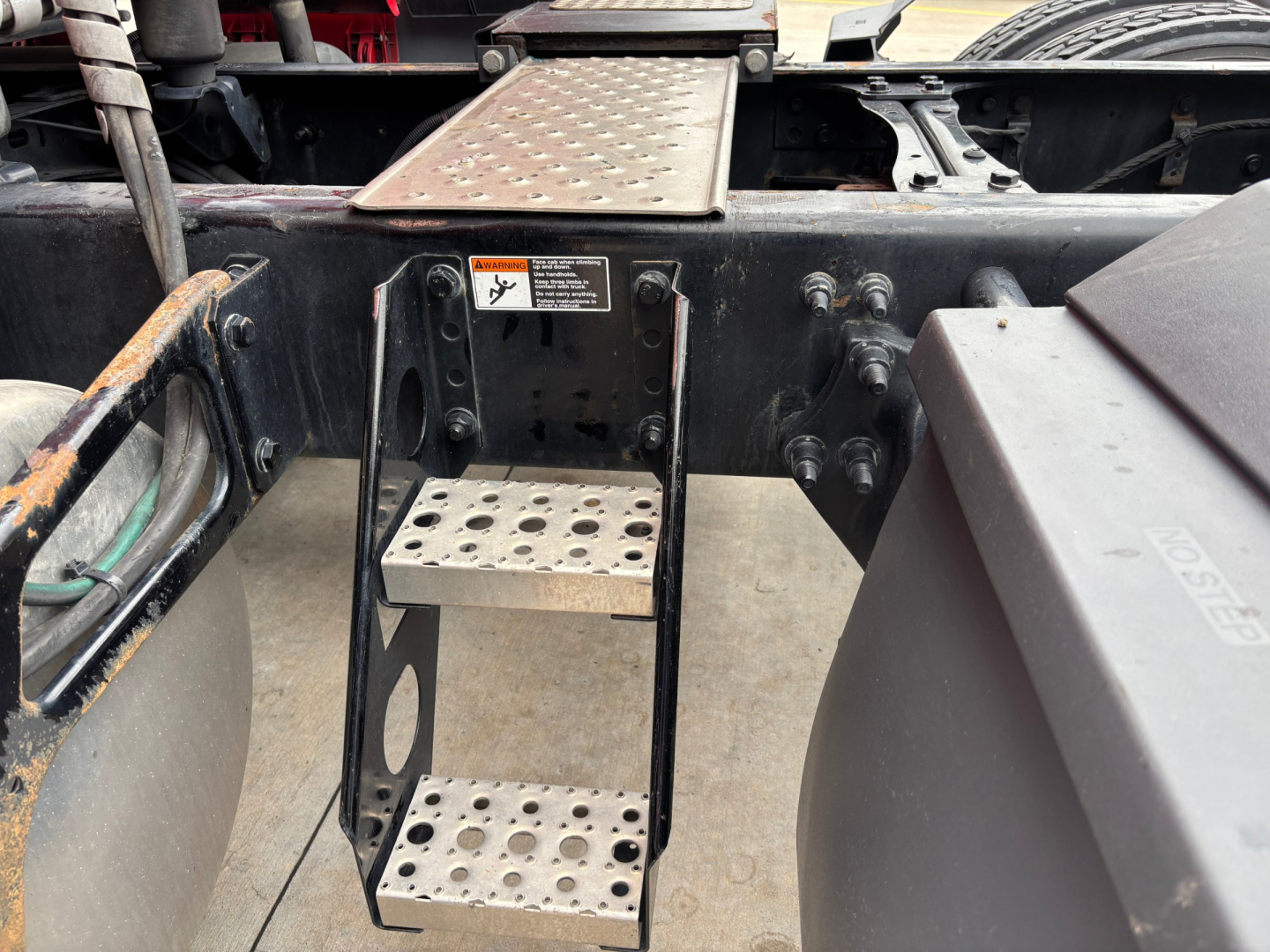 Truck step ladder on Freightliner PT126064ST shows perforated metal steps and surrounding frame.