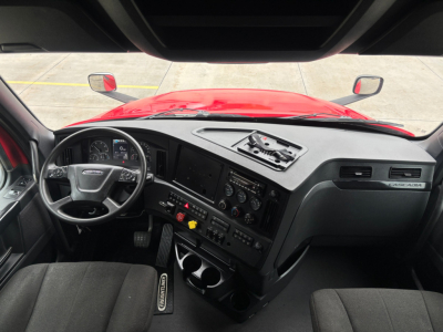 Cab interior of Freightliner PT126064ST truck showing steering wheel, dashboard, and control panel.