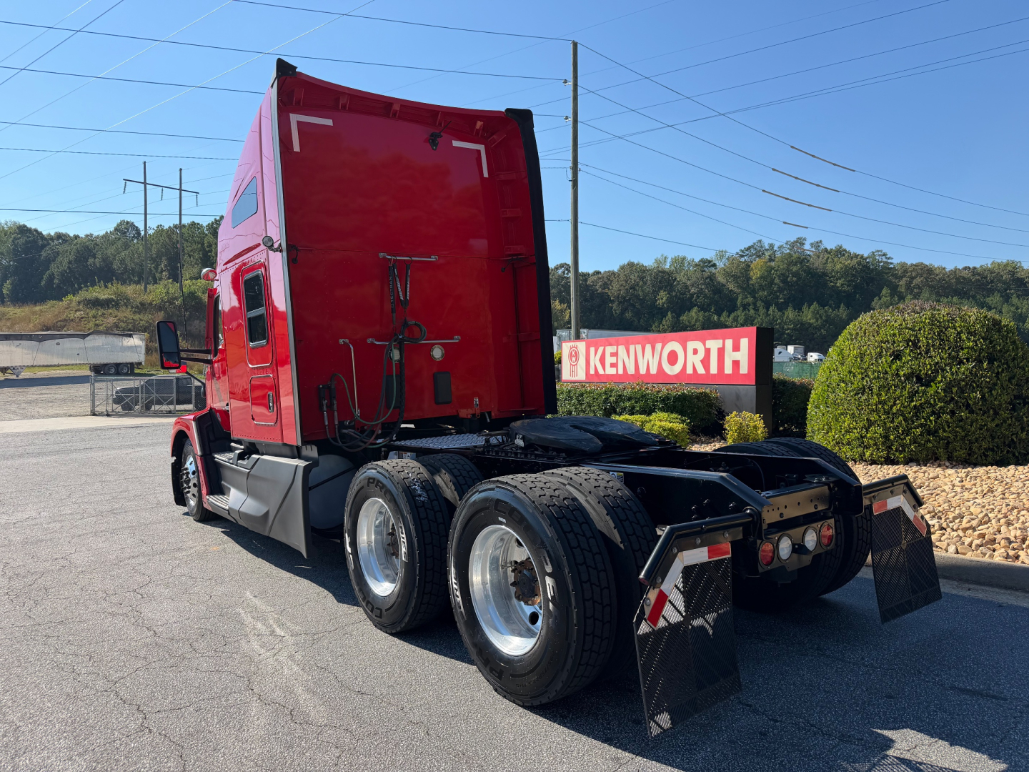 Kenworth T680 sleeper cab tractor rear view showing dual rear axles and mud flaps