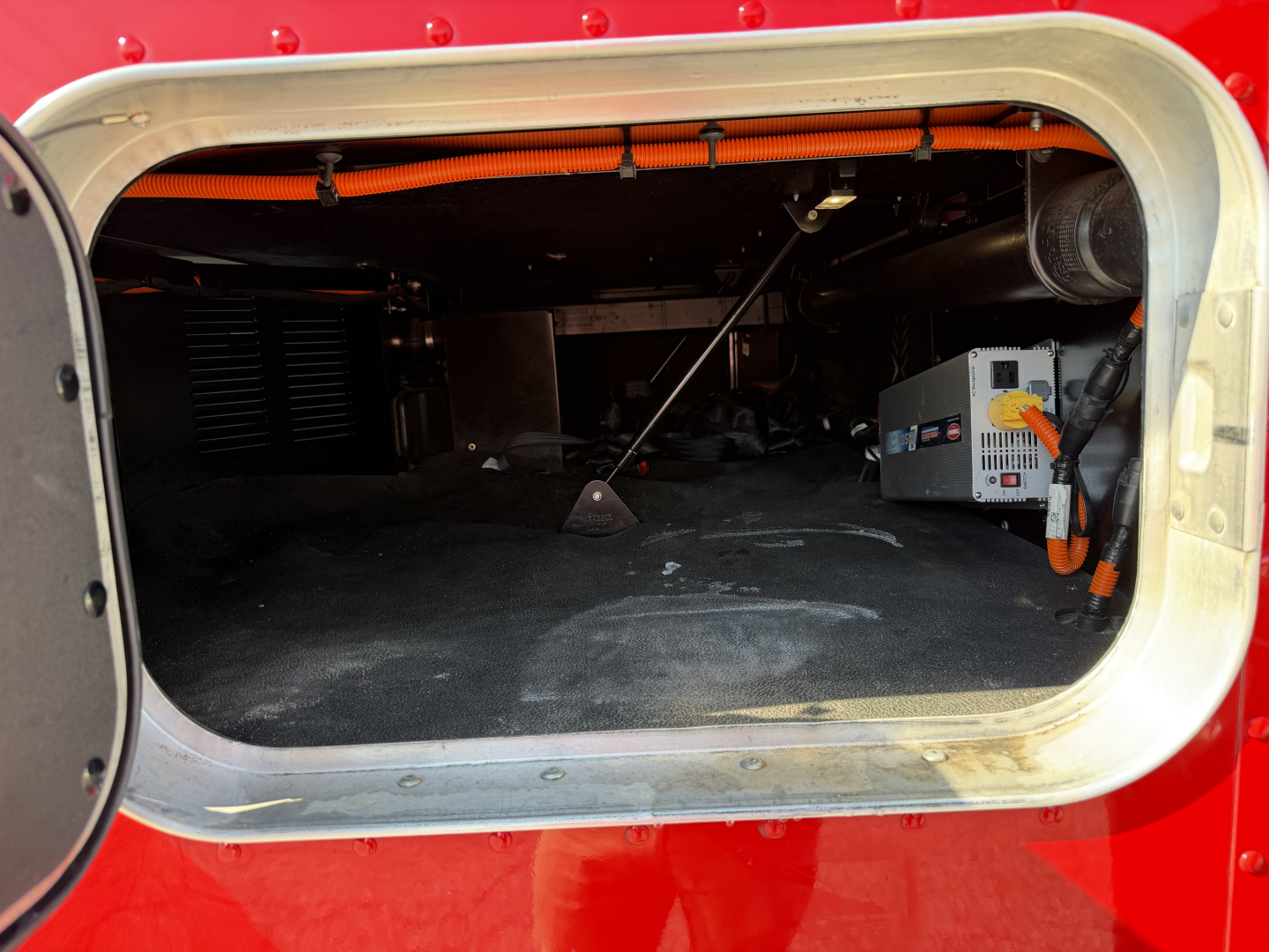Kenworth T680 truck cab area showing under-seat storage and electrical components in the doorway pocket.