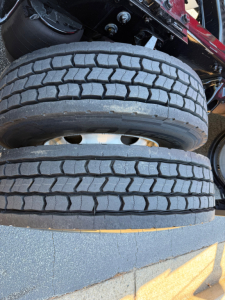 Kenworth T680 truck wheel/tire stack showing dual rear axles and tread pattern.