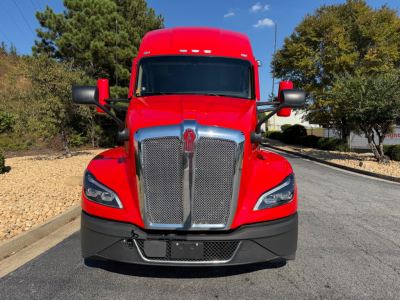 Kenworth T680 front view showing bold chrome grille and red cab with black bumper