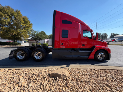 Kenworth T680 sleeper cab side view showing red truck with two rear axles and black chassis