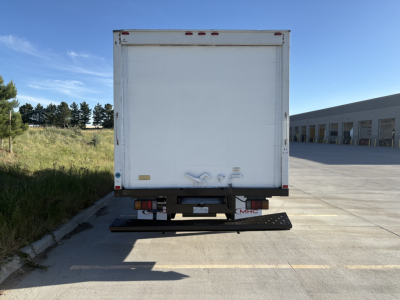 Isuzu NPR truck rear view with a white box cargo area, bumper steps, and rear lights; no legible branding or text visible on the back door.