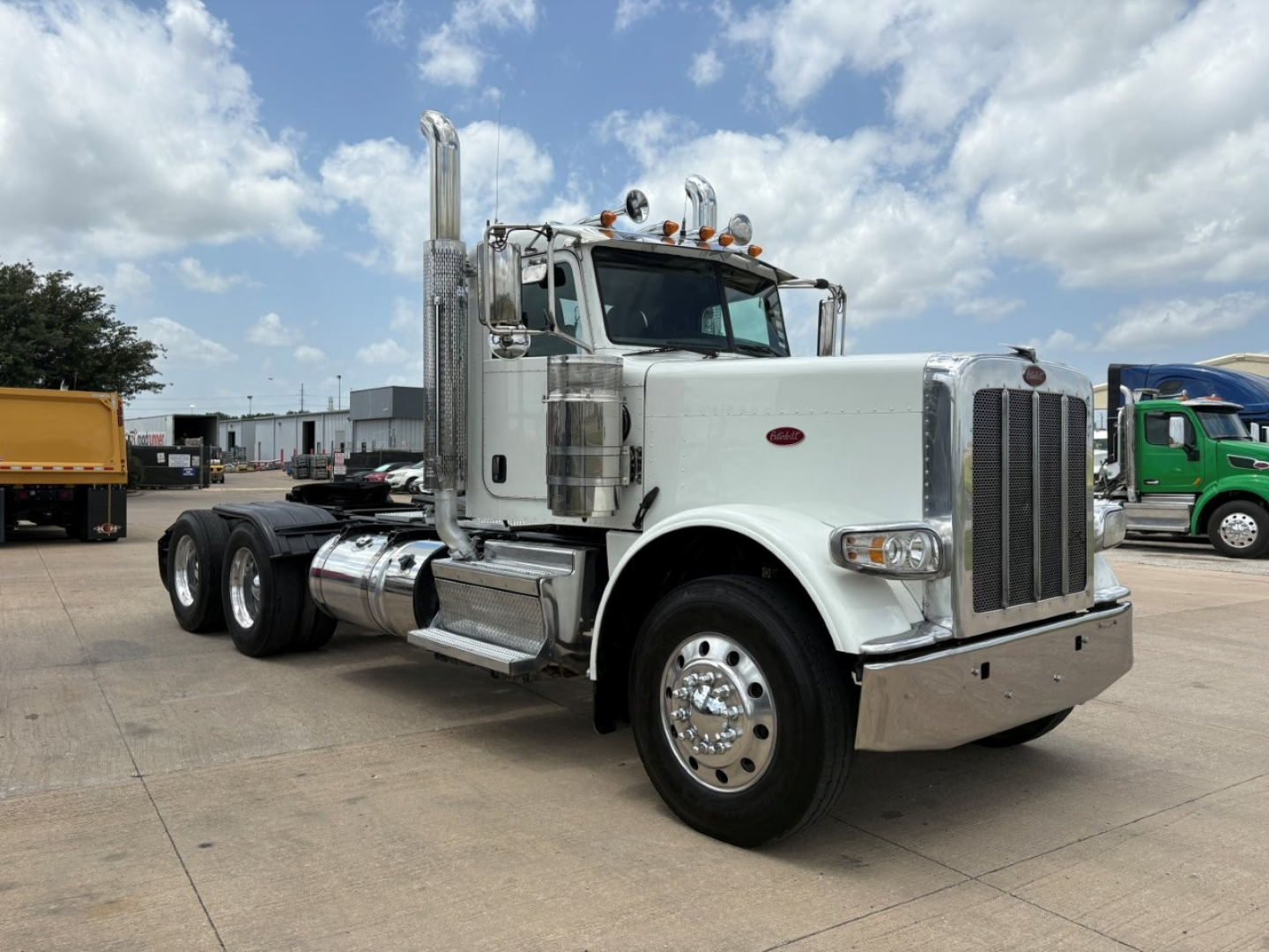 Peterbilt 389 conventional daycab truck in white, front driver-side angle, dual rear axles, chrome exhaust stacks, large grille, cab-mounted mirrors, with stock number B3444.