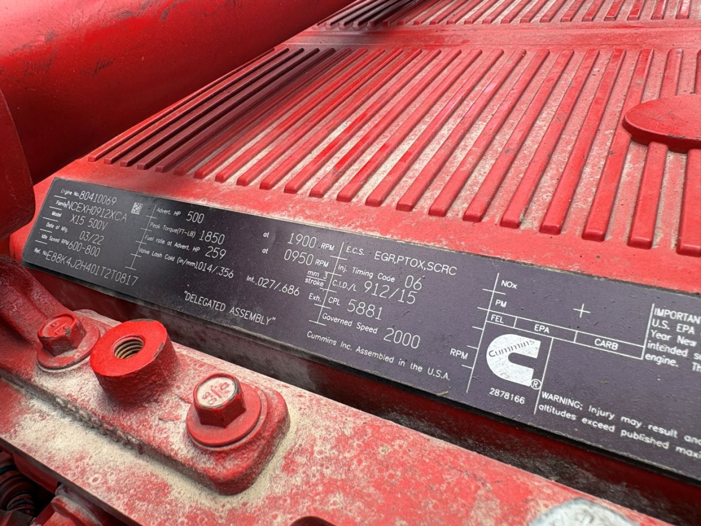 Peterbilt 389 engine bay label showing VIN and specifications plate with DOT and engine data.
