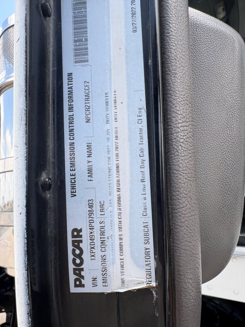 Vehicle data plate on Peterbilt 389 showing VIN 1XPXD49X4PD798403, engine and family name details, emission control information label with PacCAR branding.