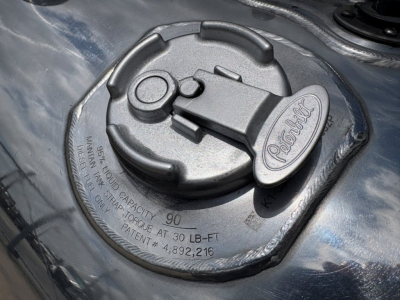 Peterbilt fuel tank cap on a 2023 Peterbilt 389 conventional daycab showing fuel cap with embossed Peterbilt logo and capacity markings.