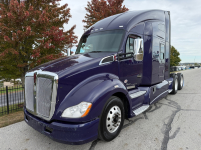 Kenworth T680 2021 conventional sleeper truck in dark purple showing front grille and side cab with chrome mirrors.