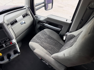 Kenworth T680 cabin interior showing driver seat and dashboard with gray upholstery and control panel