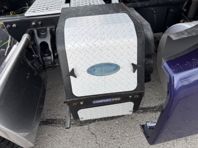 Kenworth truck air step with diamond plate surface and Comfort Pro badge, mounted between doors of a 2021 T680 conventional sleeper.