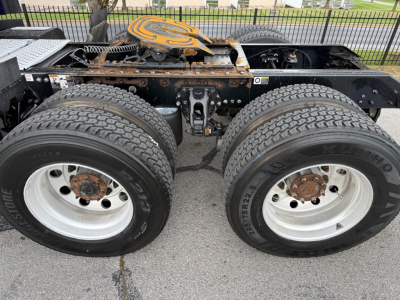 Kenworth T680 chassis with dual rear axles and wheels, visible frame, fifth wheel, and spare tire cover.