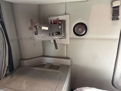 Kenworth T680 sleeper cab interior showing instrument panel mounting bracket and circular fuel cap port on light gray panel.