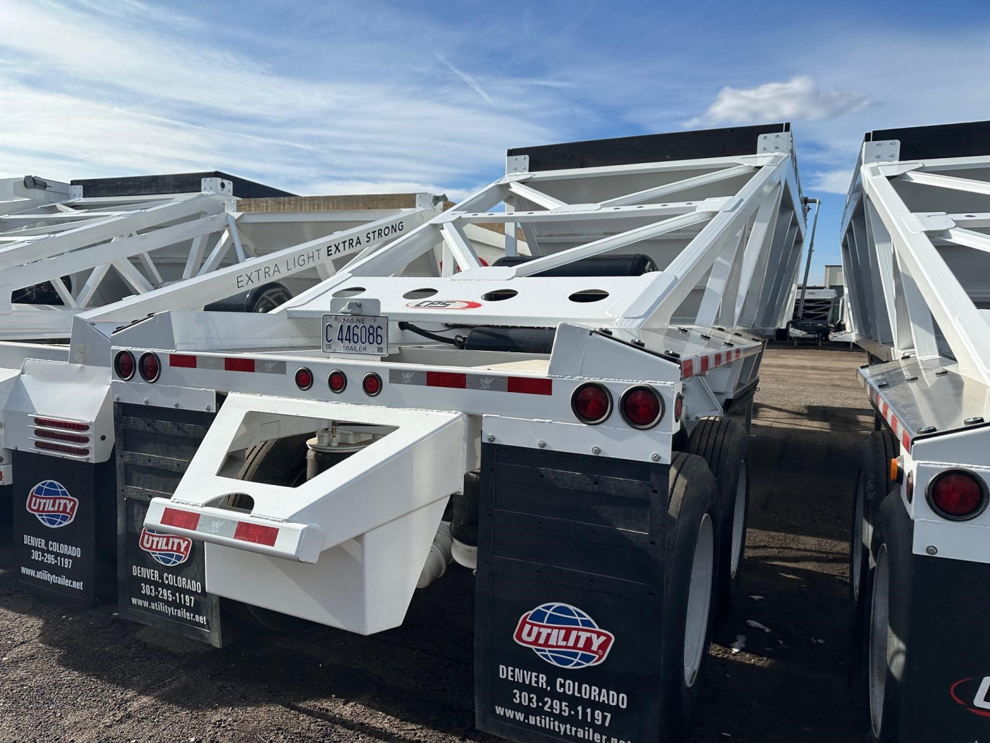 Trailer chassis and air ride bottom dump trailer showing white frame and dual axles.