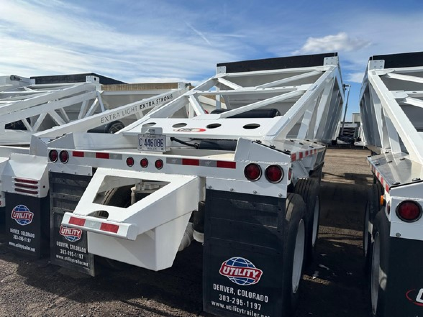 Trailer chassis of CPS air ride bottom dump showing white frame, rear lights, mud flaps with Utility logos, and license plate area.